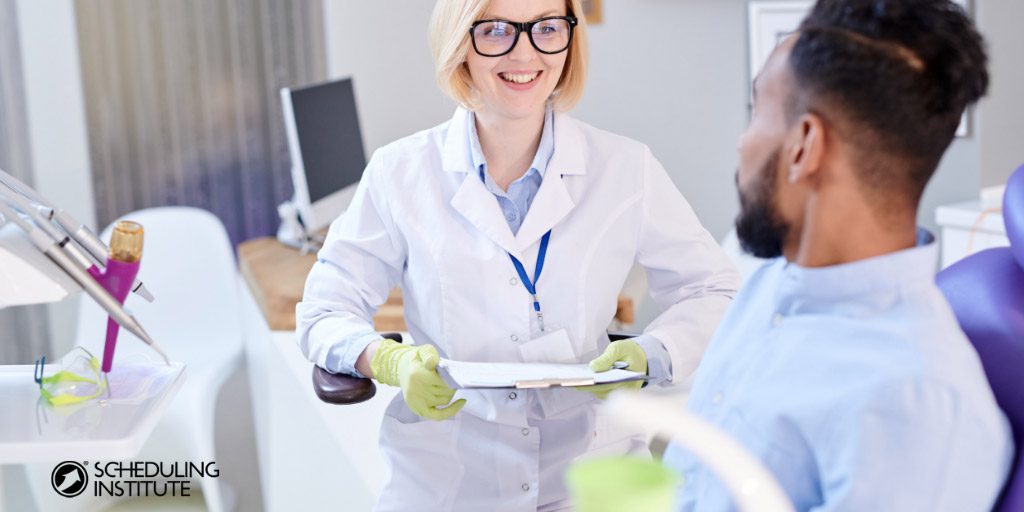 dentist speaking with patient in a dental chair