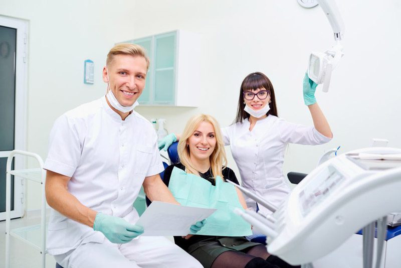 dentist, dental tech and patient smile at the camera this is a reminder to train your staff